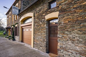 En bygning i sten med en garageport og et skilt, der viser 'Pension R. Habitations Casa Venancio'.