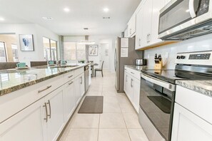 Enjoy cooking in this well-equipped kitchen with a central island, oven, and microwave.
