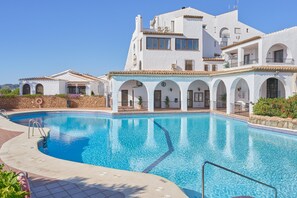 A large swimming pool with a white building in the background.