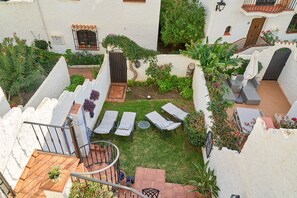 A courtyard with a small garden, outdoor seating, and a staircase.