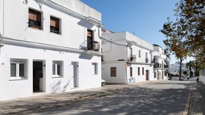 A quiet street with white buildings, a clear sky, and a few pedestrians. - Studio Apartment 'Apartamentos Maria' with Wi-Fi and Air Conditioning (Vejer de la Frontera)