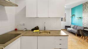 Una cocina moderna con gabinetes blancos, un lavamanos de acero inoxidable y una encimera.