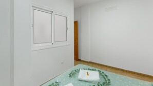 Una habitación con cama, ventana y puerta.