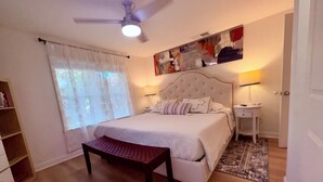 A bedroom with a bed, bedside tables, a ceiling fan, a window with curtains, and a rug. - Private marsh views -under mossy oaks, minutes to beaches & downtown’s  (Fernandina Beach)