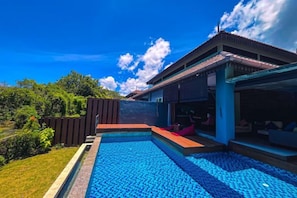 A modern house with a swimming pool, a covered patio, and a view of the surrounding greenery. - Royale Riviera Resort Private Pool Villas (Langkawi)