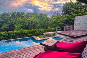 A wooden deck with a pool, surrounded by lush greenery and a cloudy sky. - Royale Riviera Resort Private Pool Villas (Langkawi)