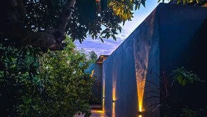A pathway flanked by lush greenery and illuminated walls, leading to a building. - Royale Riviera Resort Private Pool Villas (Langkawi)