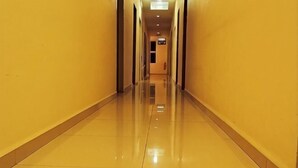 A long, narrow hallway with a shiny floor and yellow walls.
