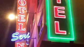Um letreiro de neon com a palavra 'HOTEL' em vermelho e verde.