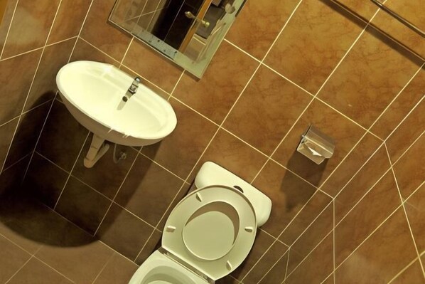 A bathroom with a white sink, a toilet, and a mirror. - Hotel Seri Nilai (Nilai)