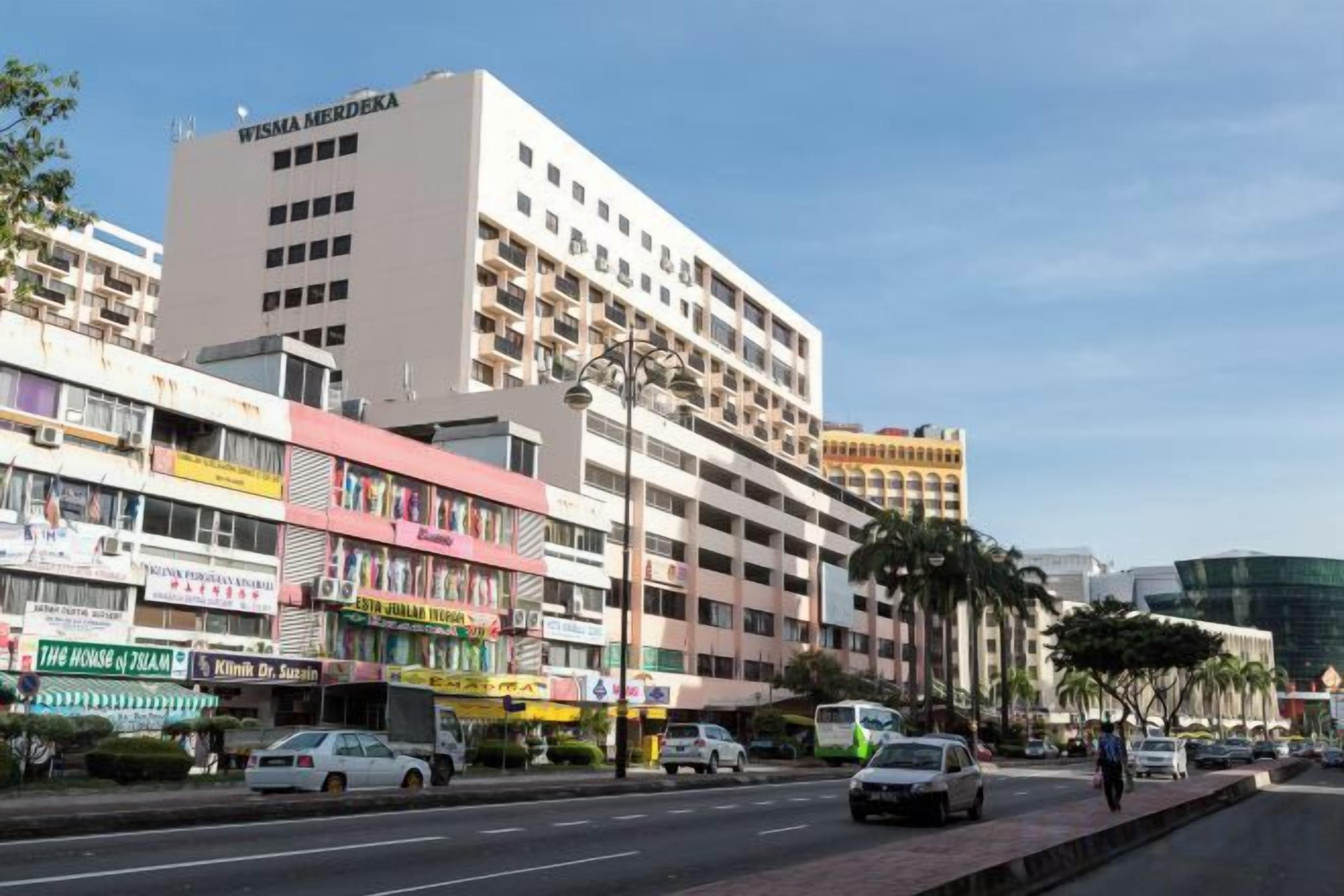 A multi-story building with a prominent sign reading 'WISMA MERDEKA' on the top.