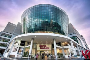 En modern byggnad med en böjd glasfasad och en framträdande entré.