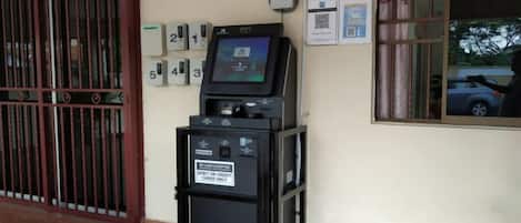 Un quiosco de autoservicio con una terminal de pago, un intercomunicador de seguridad y un ventanal con vistas al exterior.