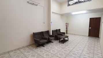 A waiting area with a reception desk, two sofas, a coffee table, and a door.