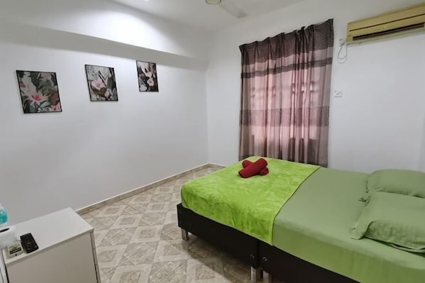 A bedroom with a bed, a desk, and a wall-mounted air conditioner. - Rivermoon Kuantan (Kuala Kuantan)