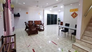A spacious room with a dining area, a sofa set, and a staircase. - Rivermoon Kuantan (Kuala Kuantan)
