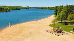 An aerial view of a beach with a playground and a lifeguard stand. - Lakefront Suite - Spa, Firepit, Kayaks & PBall (Macon)
