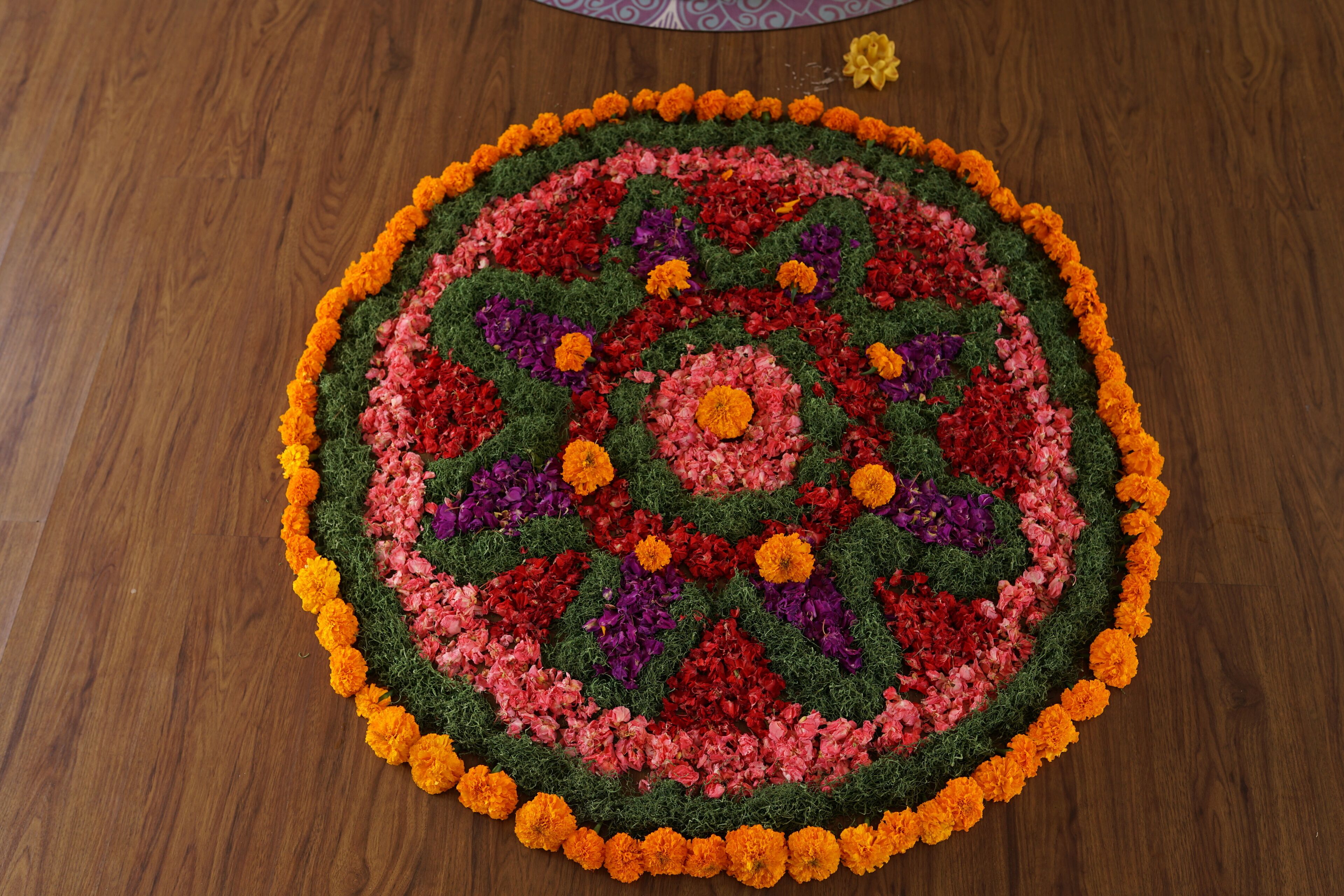 A circular floral arrangement on a wooden floor.