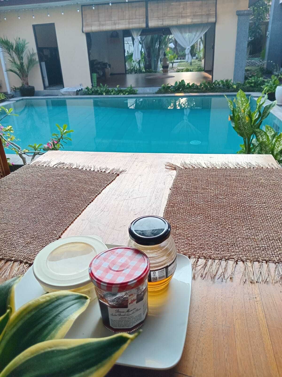 Ein Tisch am Pool mit Unterlage, Marmeladenglas und Teller.