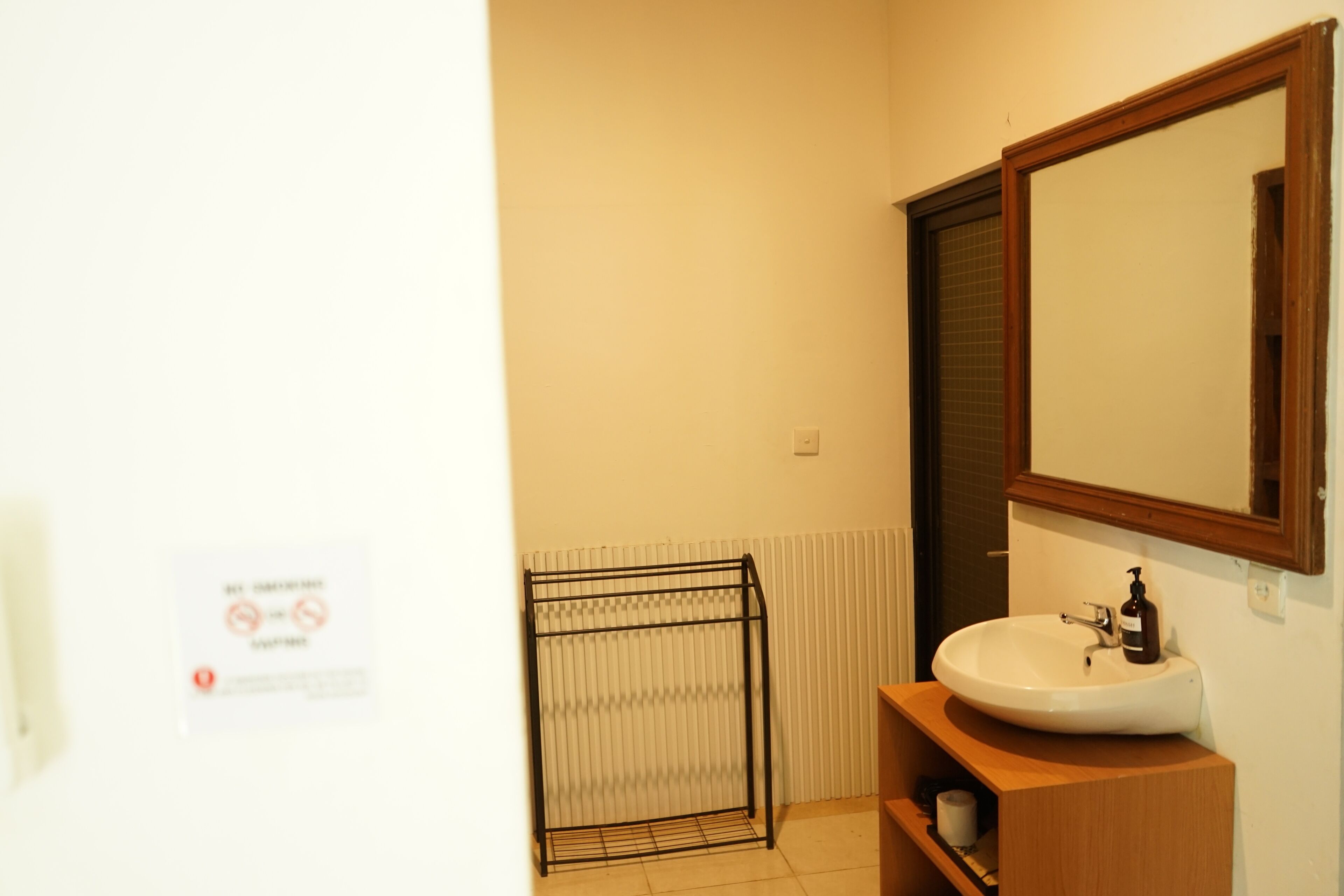 Une salle de bain avec un lavabo blanc, un meuble-lavabo en bois et un miroir.