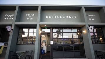 Un bâtiment dont la devanture porte l’inscription « BOTTLECRAFT » et qui affiche une pancarte indiquant « SALLE DE DÉGUSTATION ».