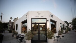 Un edificio con una insegna che recita 'COMMUNAL' e il numero '502' sopra l'ingresso.