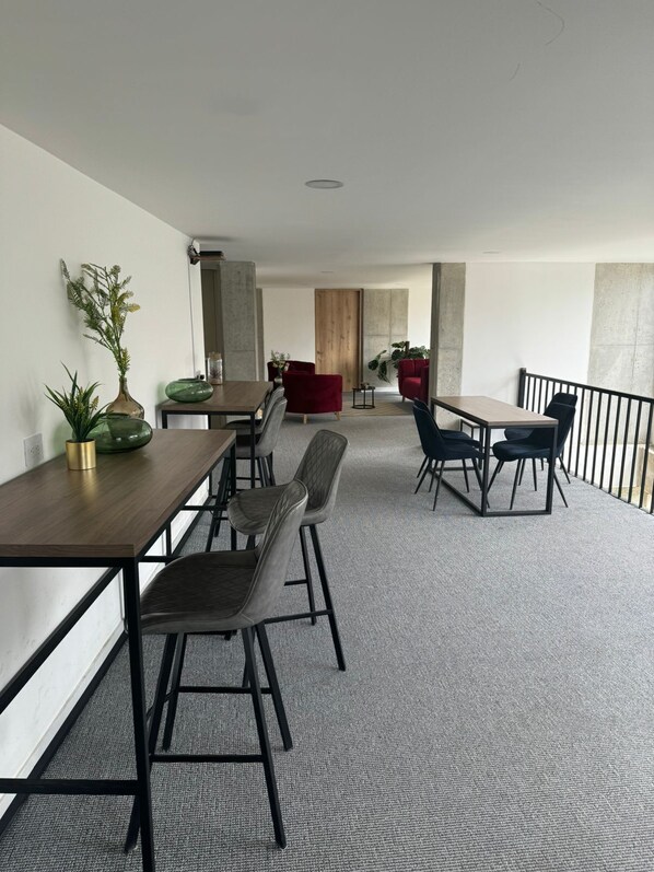 A modern office space with a long wooden table, several chairs, and a red sofa. - Charming studio in lovely Bogotá with WiFi (Bogotá)