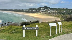 Une vue sur la côte avec un panneau indiquant « Plage du phare ».