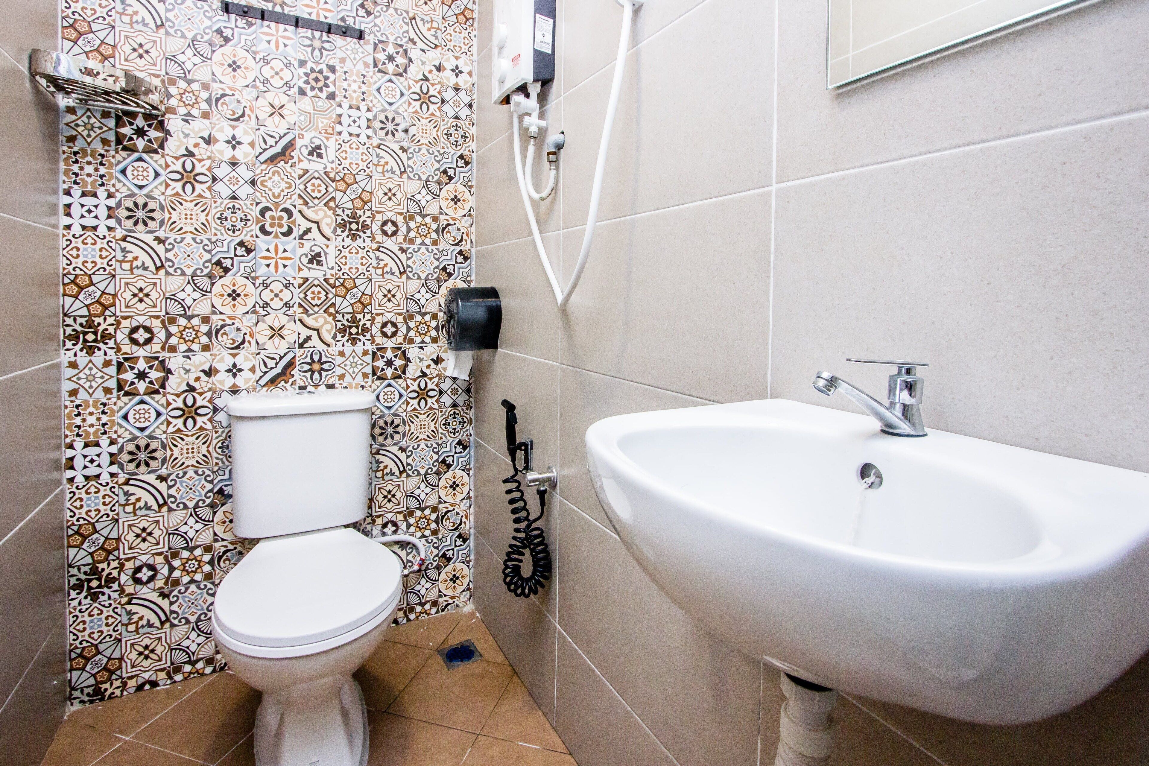 A bathroom with a toilet, a sink, and a shower.