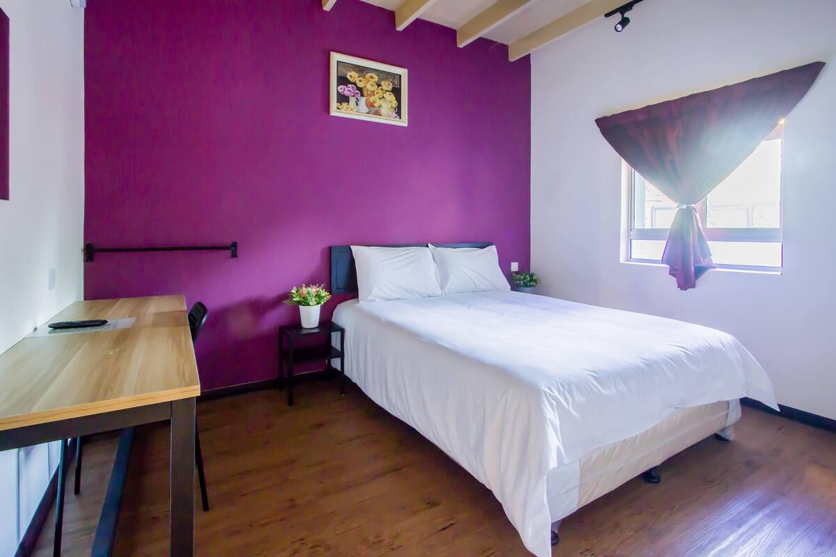 Ein Zimmer mit einem Bett, einem Schreibtisch und einem Stuhl.