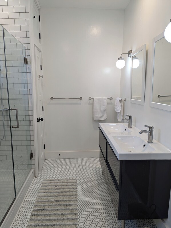A modern bathroom with a glass shower enclosure, two sinks, and a large mirror. - 2 Min to RPI Modern Space + Fast WiFi (Troy)