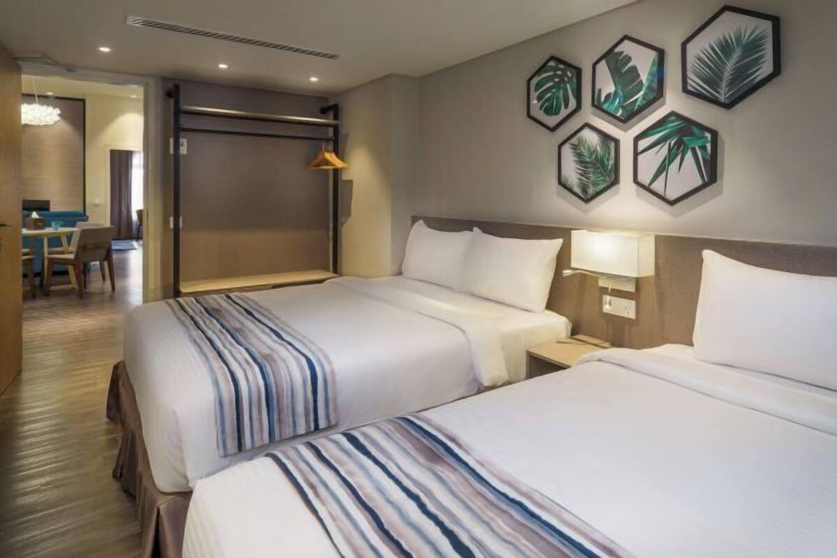 Ett hotellrum med två sängar, ett skrivbord och en stol.