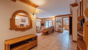 A spacious living area with a fireplace, wooden furniture, and a view of the kitchen and dining area. - Le Cristal MB8 Mountain View, Pool, Parking & Free WiFi, Argentière (Chamonix), France (Argentière (Chamonix))