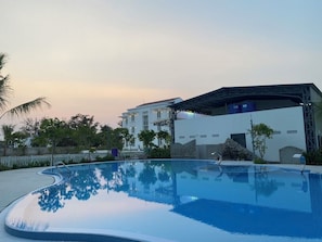 A swimming pool with a clear view of a building in the background. - Viet Huong Hotel (Phan Ri Cua)