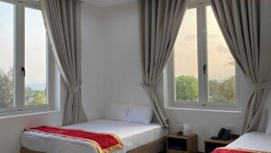 Habitación de hotel con dos camas, ventanas amplias y suelo de mármol.