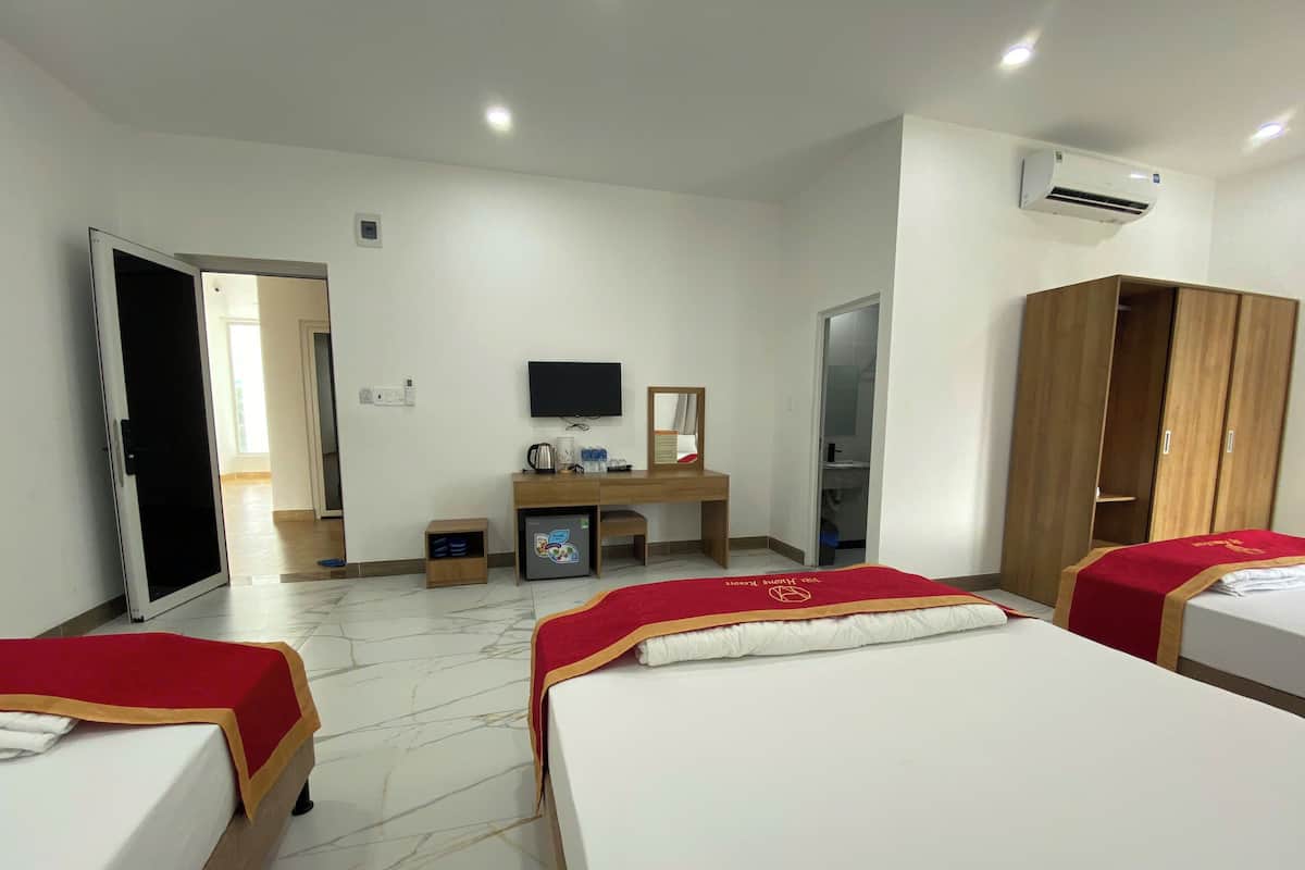 Une chambre d’hôtel avec deux lits, un bureau, une télévision et un appareil de climatisation.