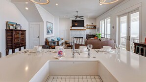 A spacious kitchen with a large island, modern appliances, and a view to the outside.