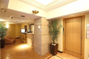 Un vestíbulo de hotel con mostradores de recepción, zona de recepción y personal de recepción.