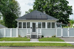 A single-story house with a front porch, a garage, and a fenced yard.
