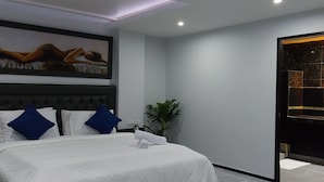 A modern bedroom with a large bed, a ceiling light, and a wall-mounted TV.
