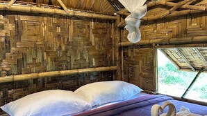 A room with a bed, a hanging mosquito net, and a woven bamboo ceiling. - Three ladies (Ko Yao)