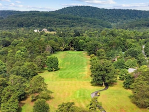A golf course surrounded by dense forest and hills. - Cozy Woods Retreat w/Screened Porch & Fire Pit (Hedgesville)