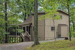A two-story cabin with a porch and stairs, surrounded by trees. - Cozy Woods Retreat w/Screened Porch & Fire Pit (Hedgesville)