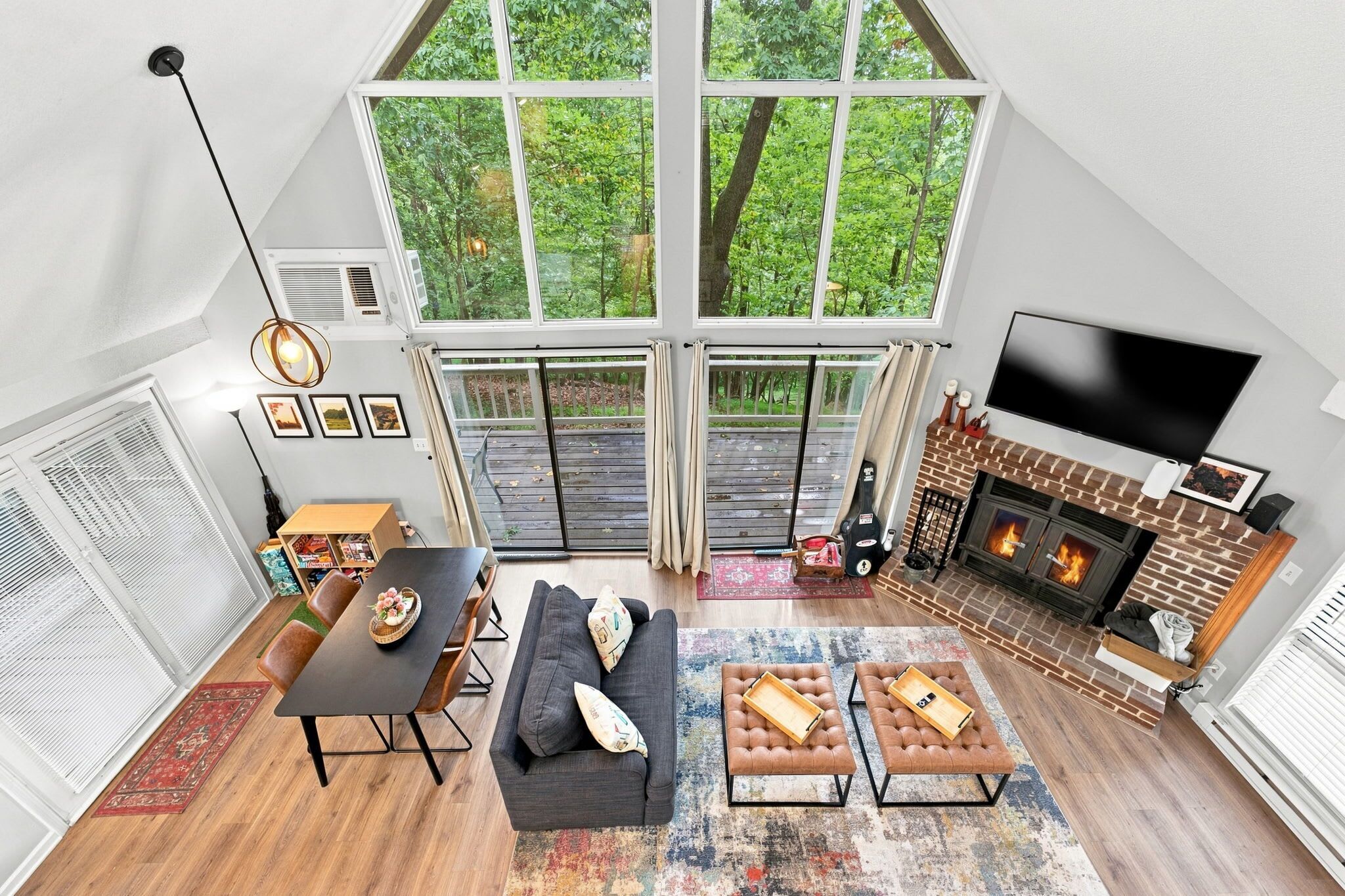 A spacious loft with a large skylight, a fireplace, and a television.