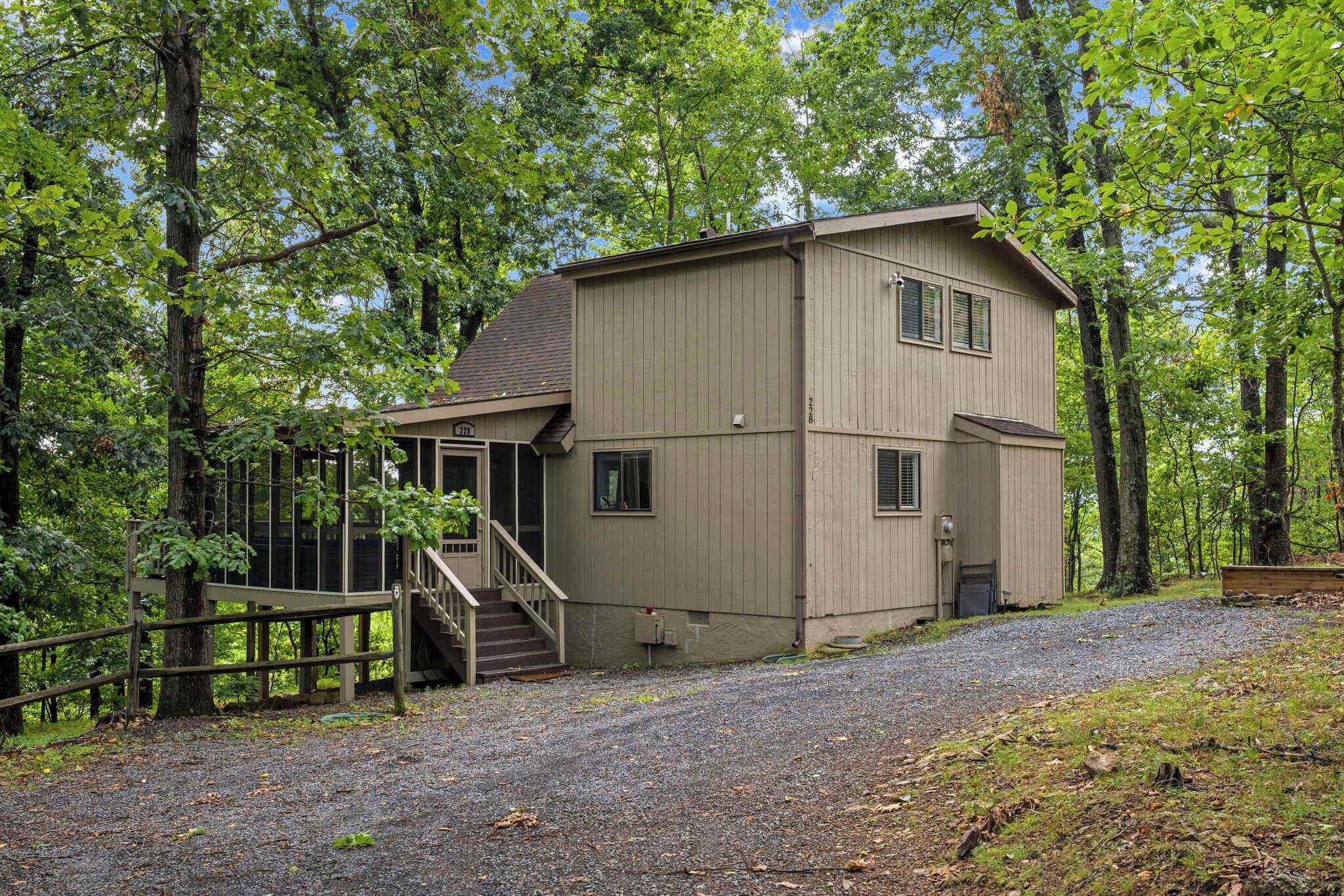 A two-story building with a wooden deck and a staircase leading to the entrance.