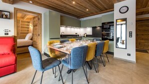 A modern kitchen with a wooden ceiling, a dining area with a table set for six, and a red sofa in the living area. - New apartment in resort center - sleeps 8/9 (ST SORLIN D ARVES)