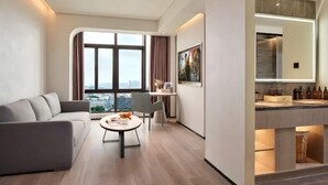 Un salon moderne avec un canapé, une table basse et une vue sur la ville.