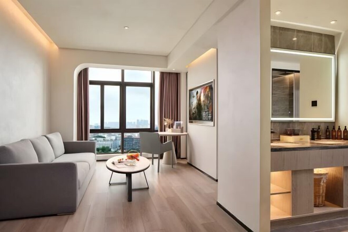 A modern living room with a sofa, coffee table, and city view.