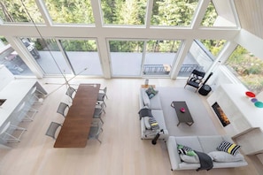 A spacious living area with a long wooden table, sofas, and a fireplace.