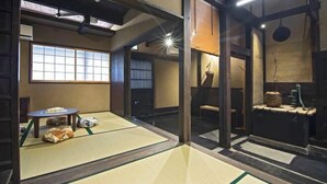 A tatami mat room with sliding doors, a traditional Japanese washbasin, and a window with shoji screens. - Onju Kamikyo (Kyoto)